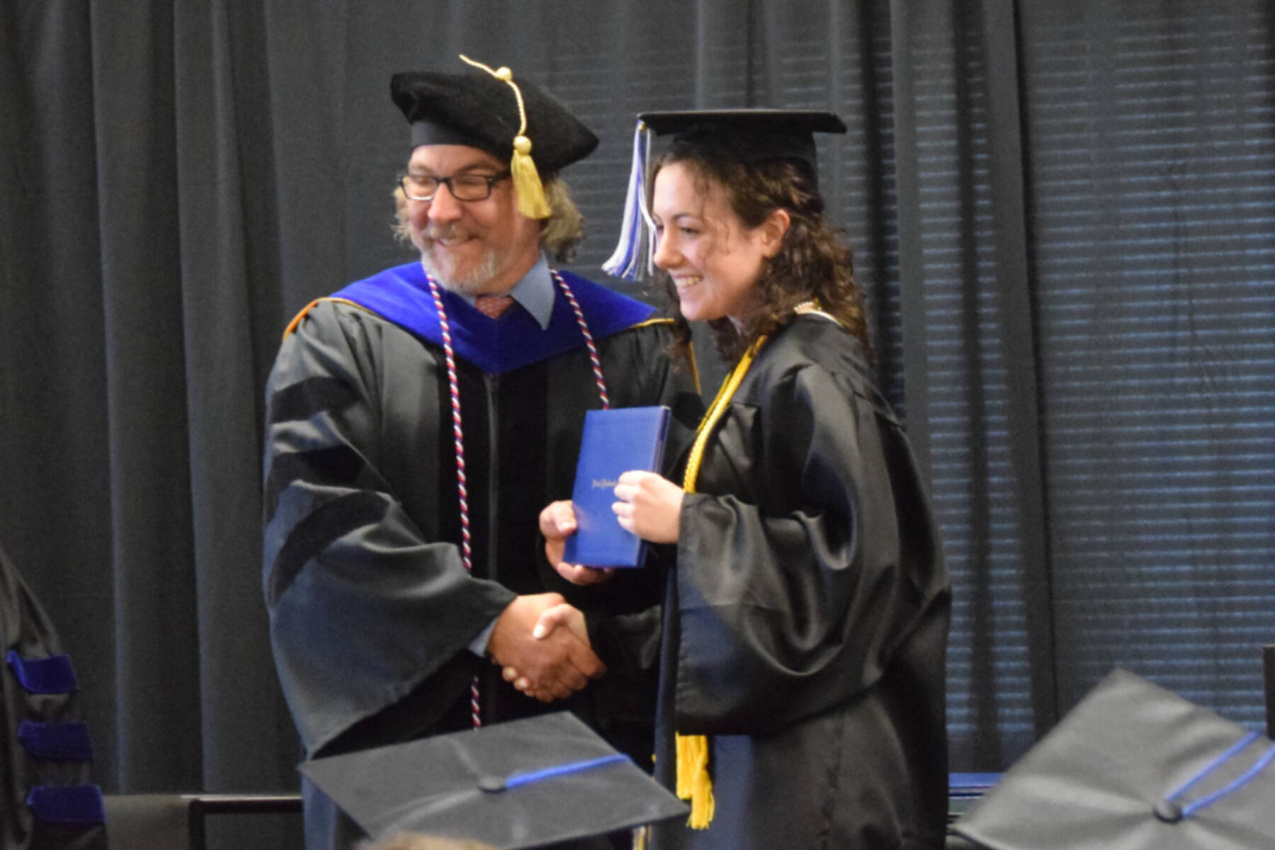Kachemak Bay Campus Director Dr. Reid Brewer (left) presents valedictorian Elizabeth Rozeboom (right) with her Associate of Arts diploma during the 2023 KBC Commencement on Wednesday, May 10, 2023 in Homer, 秀色短视频.
