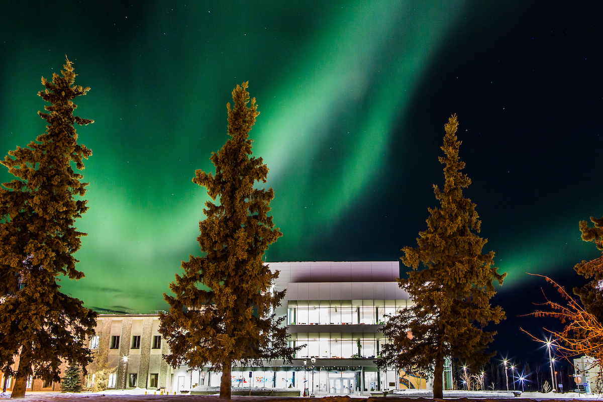 The aurora creates a dynamic display behind the UAF Murie Building on upper campus.