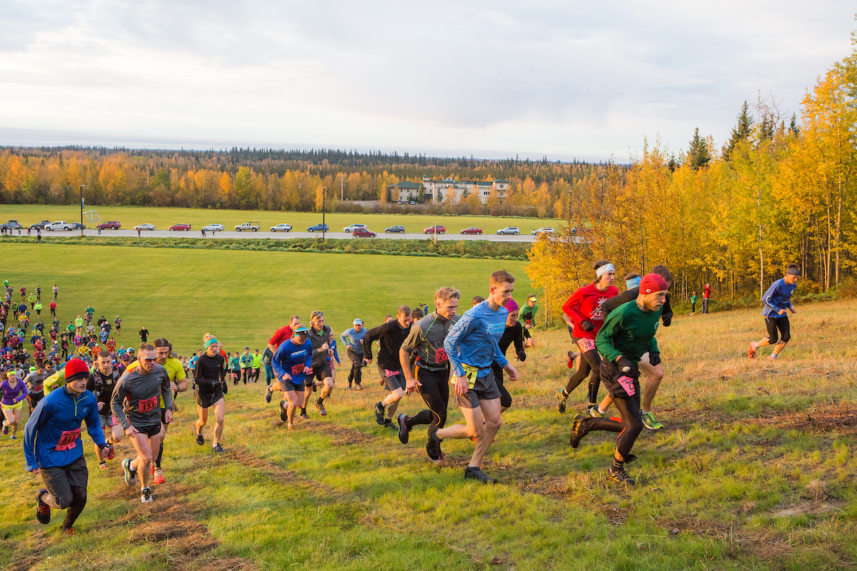Participants of the 2016 Equinox Marathon start the race by scaling the hill that overlooks Beluga Field on campus.